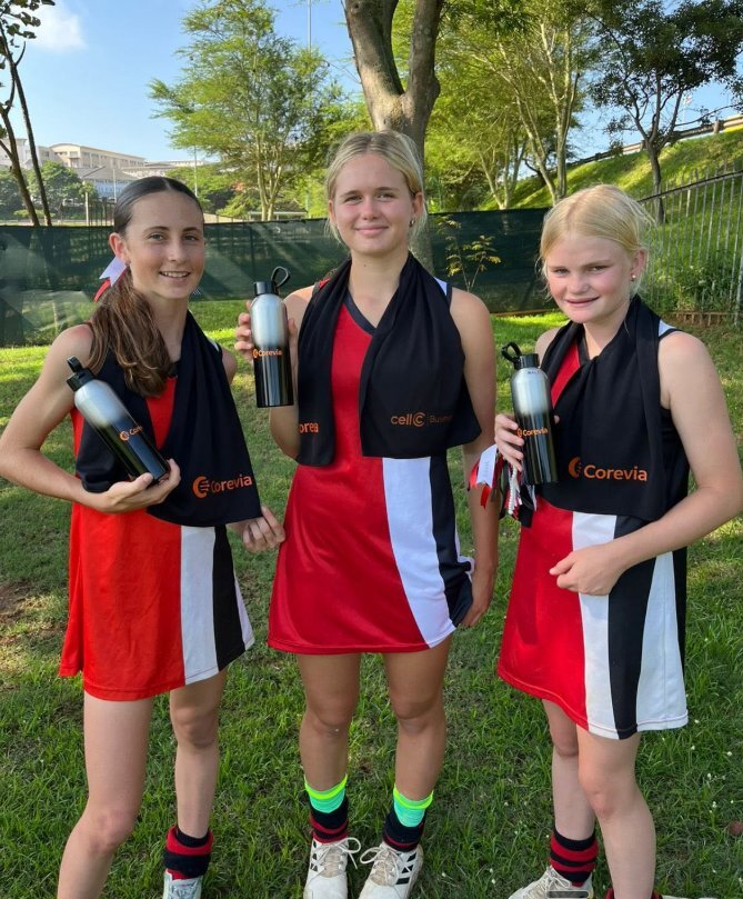 Players from the Ashton U16 Girls Hockey team with Corevia-branded water bottles and towels